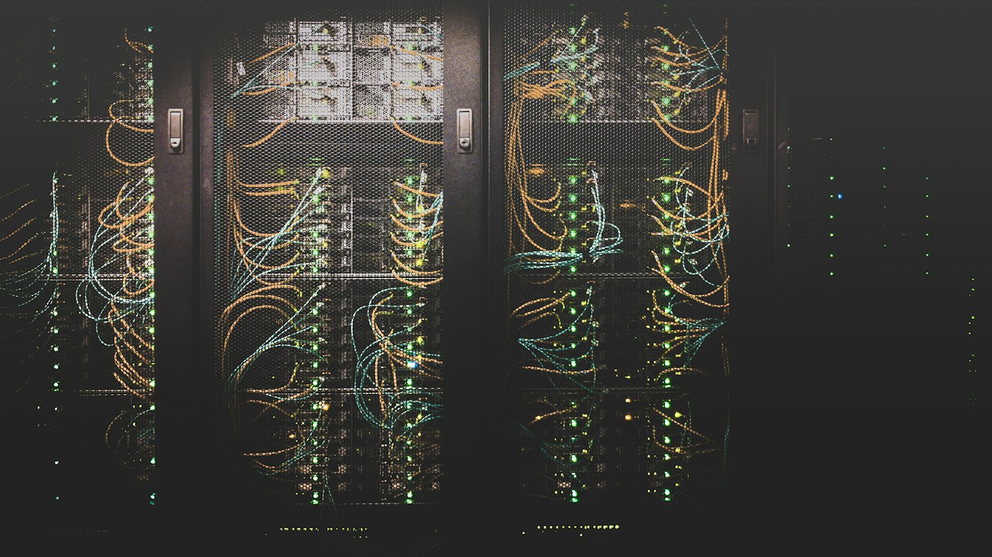 Network cables and illuminated server racks inside a data center