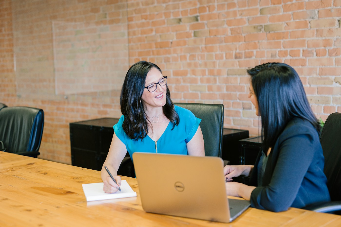 Two professionals having a focused interview-style discussion at a laptop